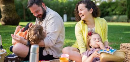 Happy family having a picnic on a sunny day in a park, enjoying togetherness and relaxation.