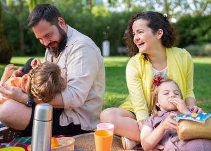 Happy family having a picnic on a sunny day in a park, enjoying togetherness and relaxation.